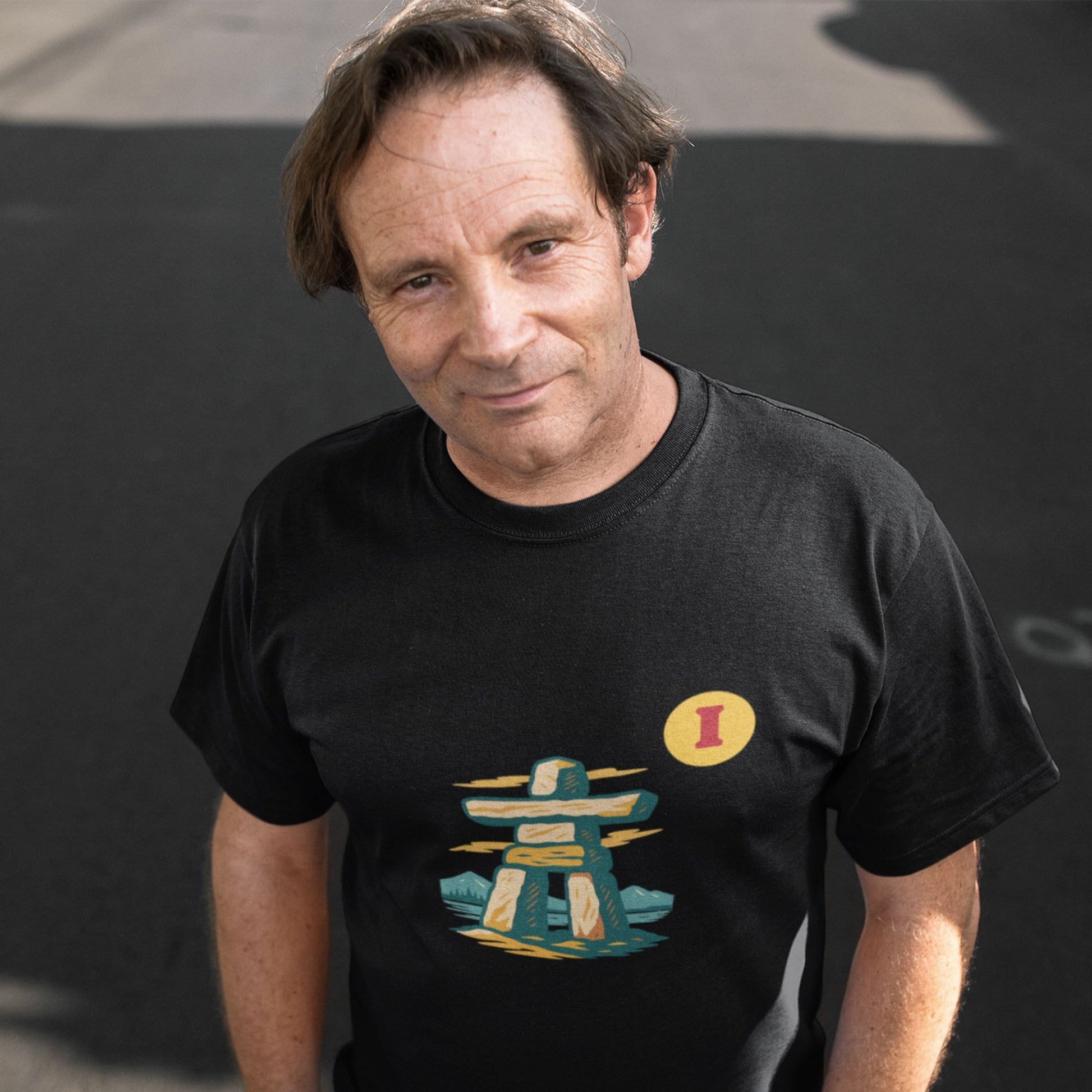 Man wearing the Canadian Made organic cotton Inukshuk T shirt in Black colour from the Canadian Alphabet collection by Maple Beaver