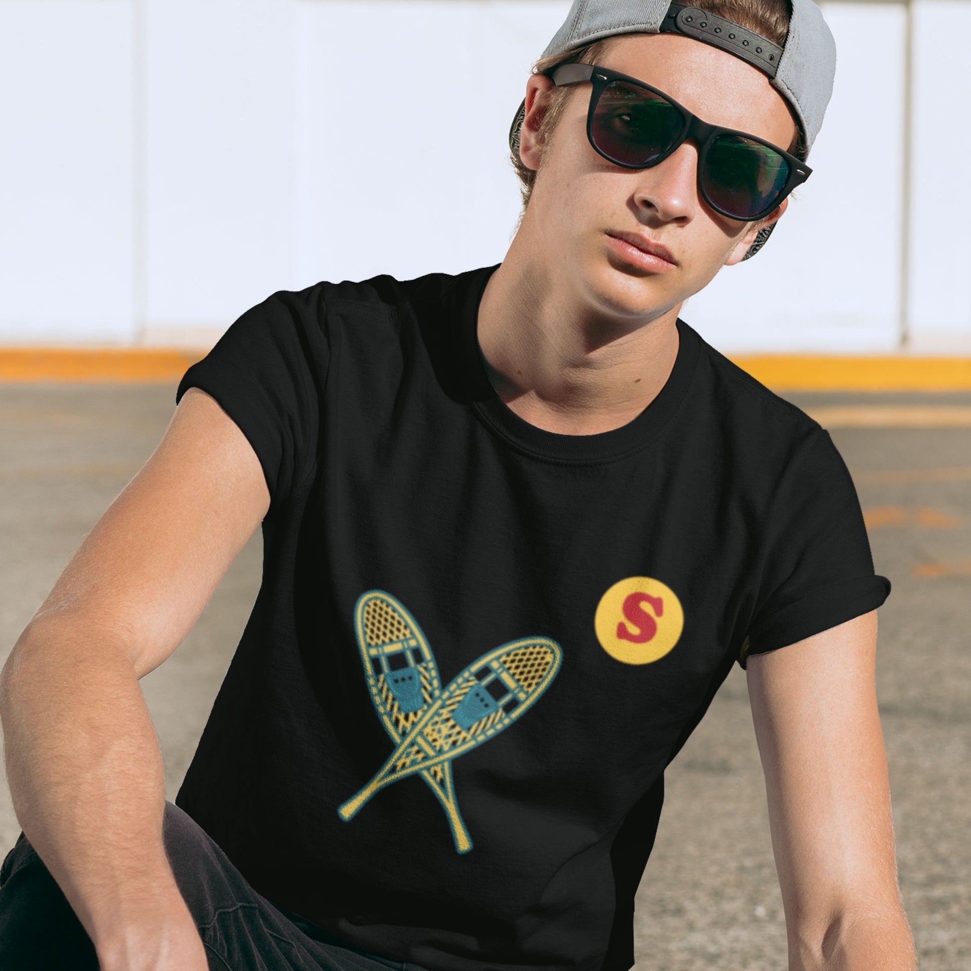 Man wearing a Canadian Made Black colour T Shirt with Snowshoes  from the Canadian ABC collection by Maple Beaver