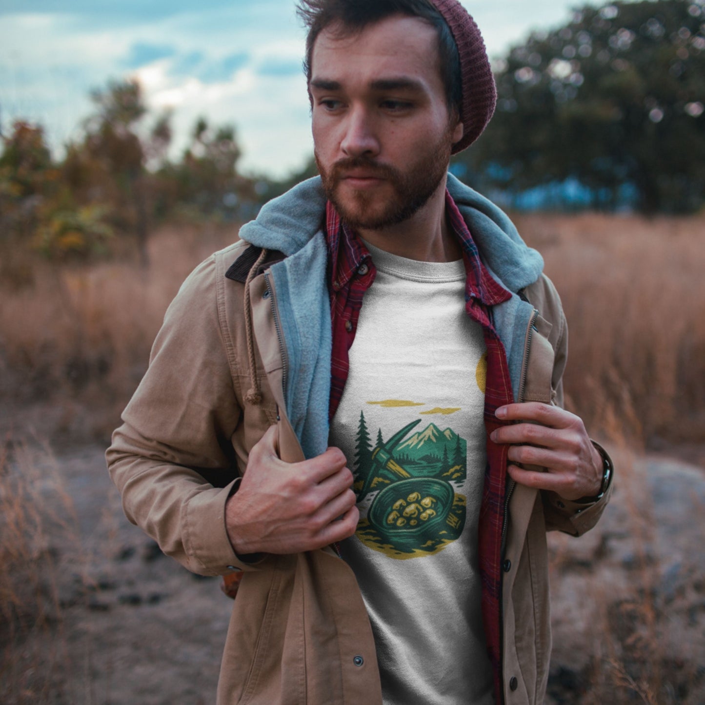 Man standing in a field wearing a jacket with the Canadian Made Yukon T shirt in White colour from the Canadian ABC collection by Maple Beaver