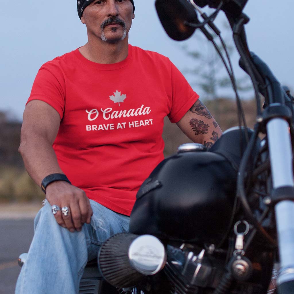 Man on a bike wearing the O Canada Brave at Heart Canadian TShirt in Red colour by Maple Beaver.