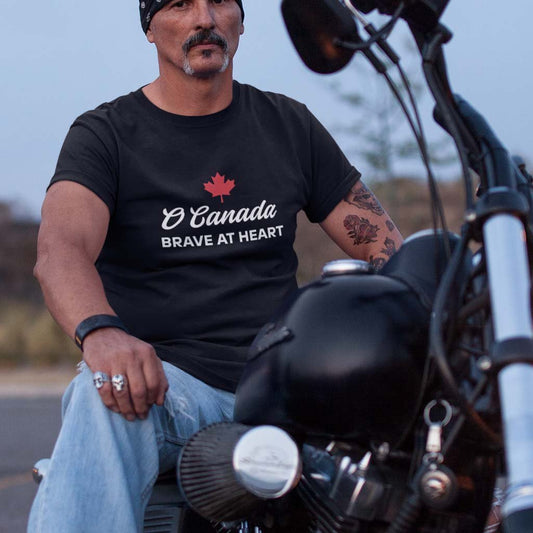 Man on a bike wearing the O Canada Brave at Heart Canadian TShirt in Black colour by Maple Beaver.