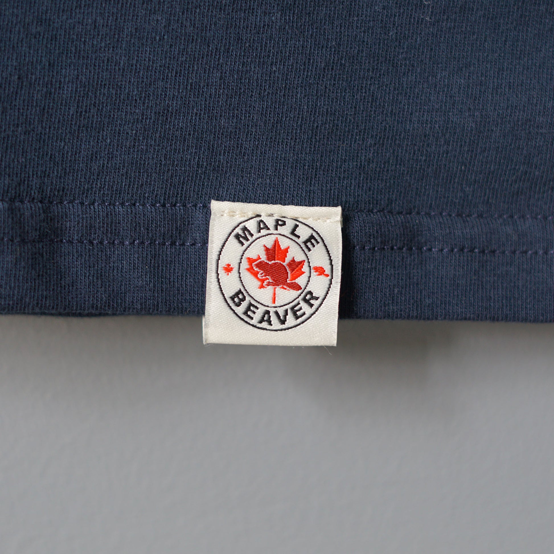 Canadian Made Organic Cotton T shirt in Navy colour by Maple Beaver, closeup of bottom hem tag.