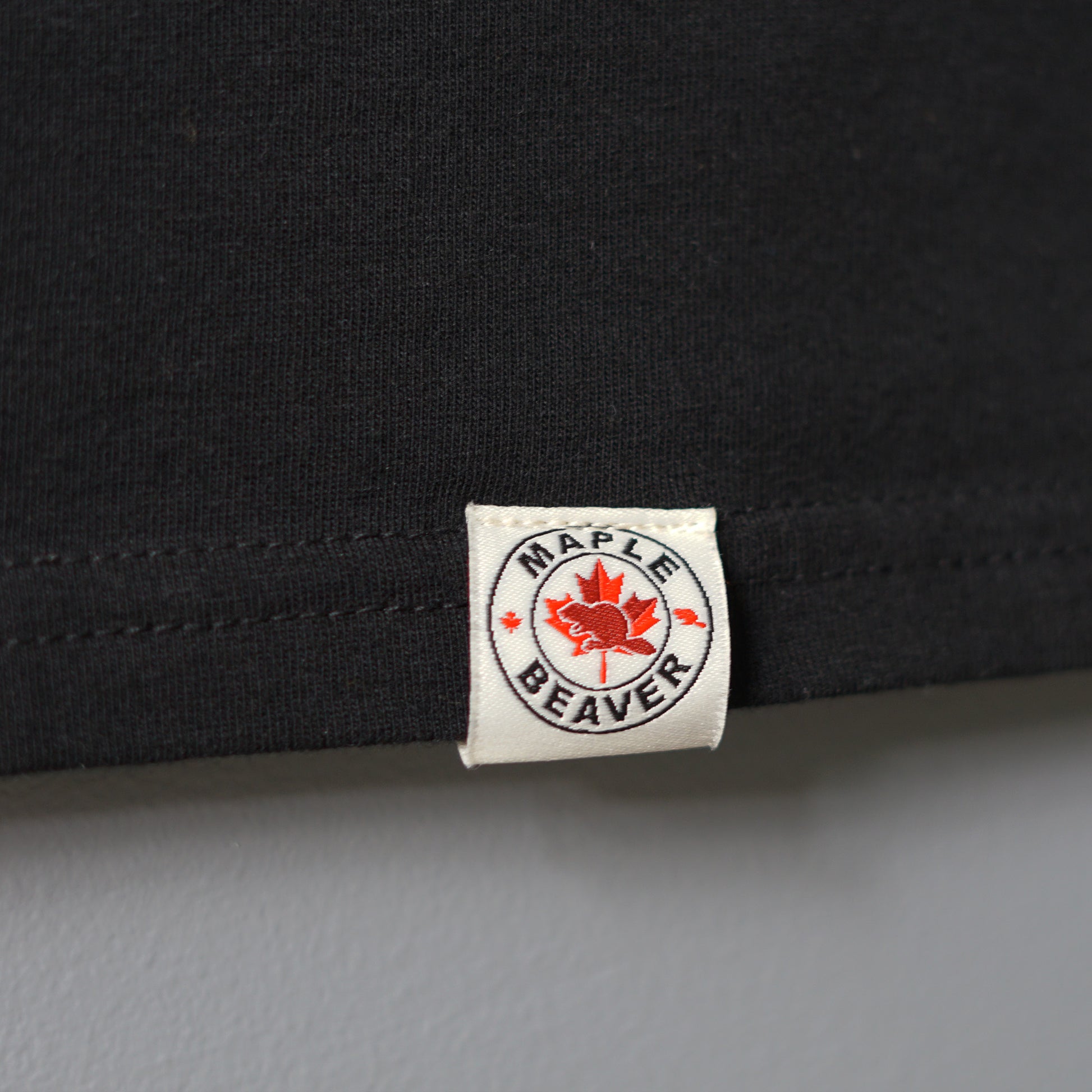 Canadian Made Organic Cotton T shirt in Black colour by Maple Beaver, closeup of bottom hem.