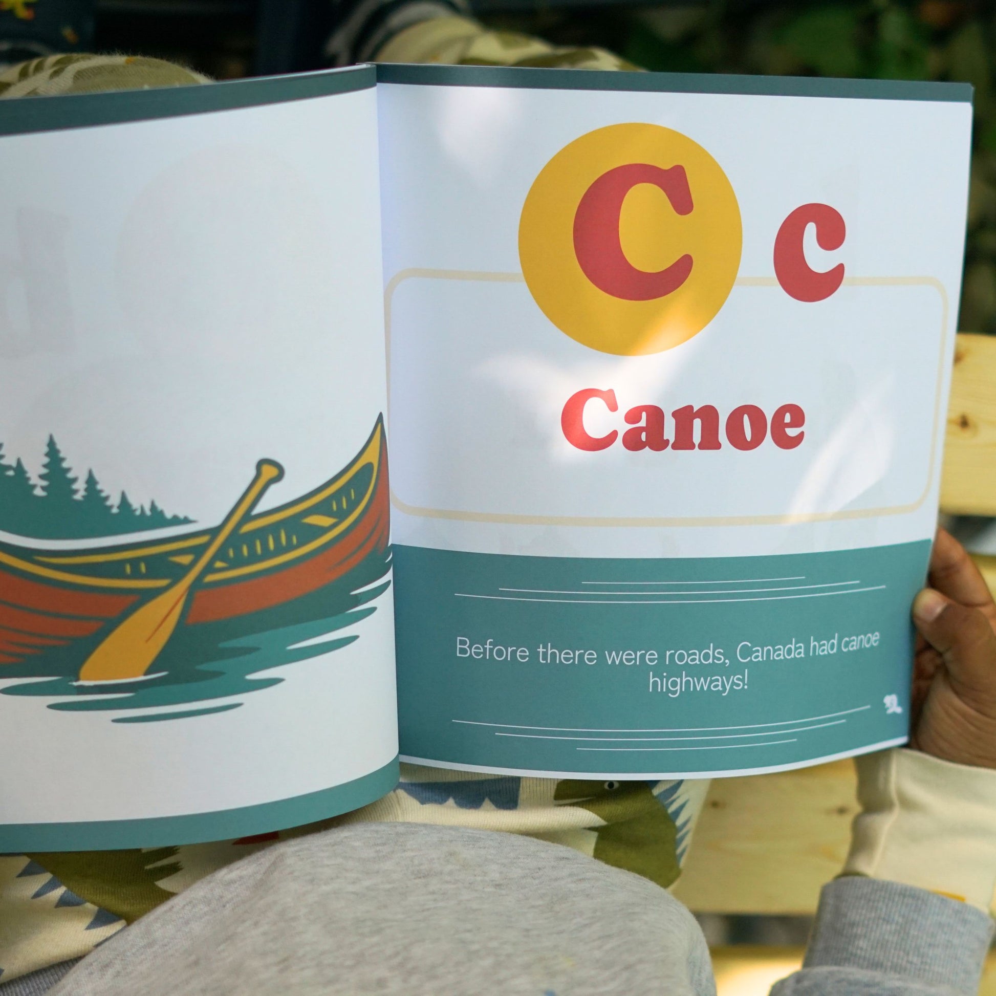 A child reading the Children's book From Aurora to Zamboni C for Canoe