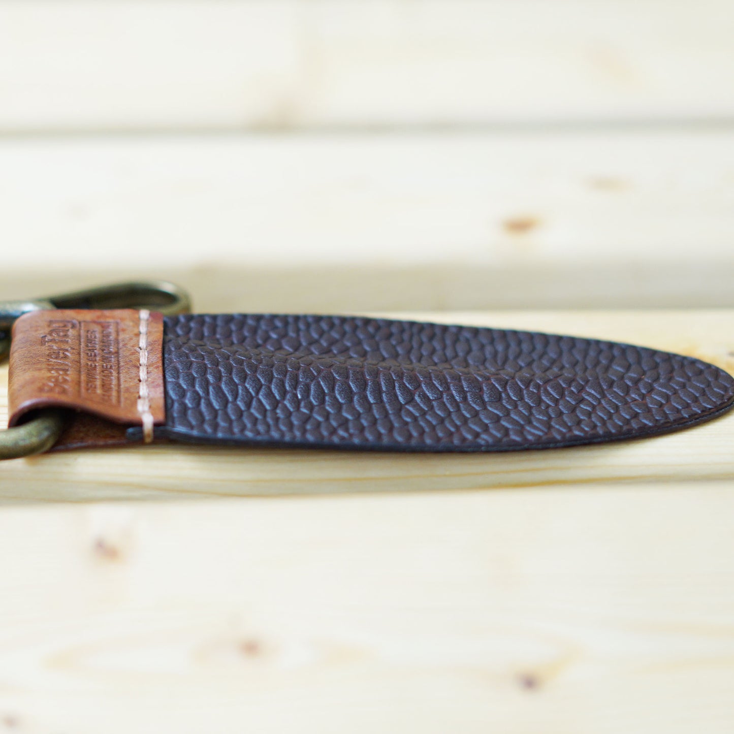 BeaverTag side shot showing the premium saddle stitch and the unique profile, thick at the center and tapering towards the edges, just like a real beaver's tail.