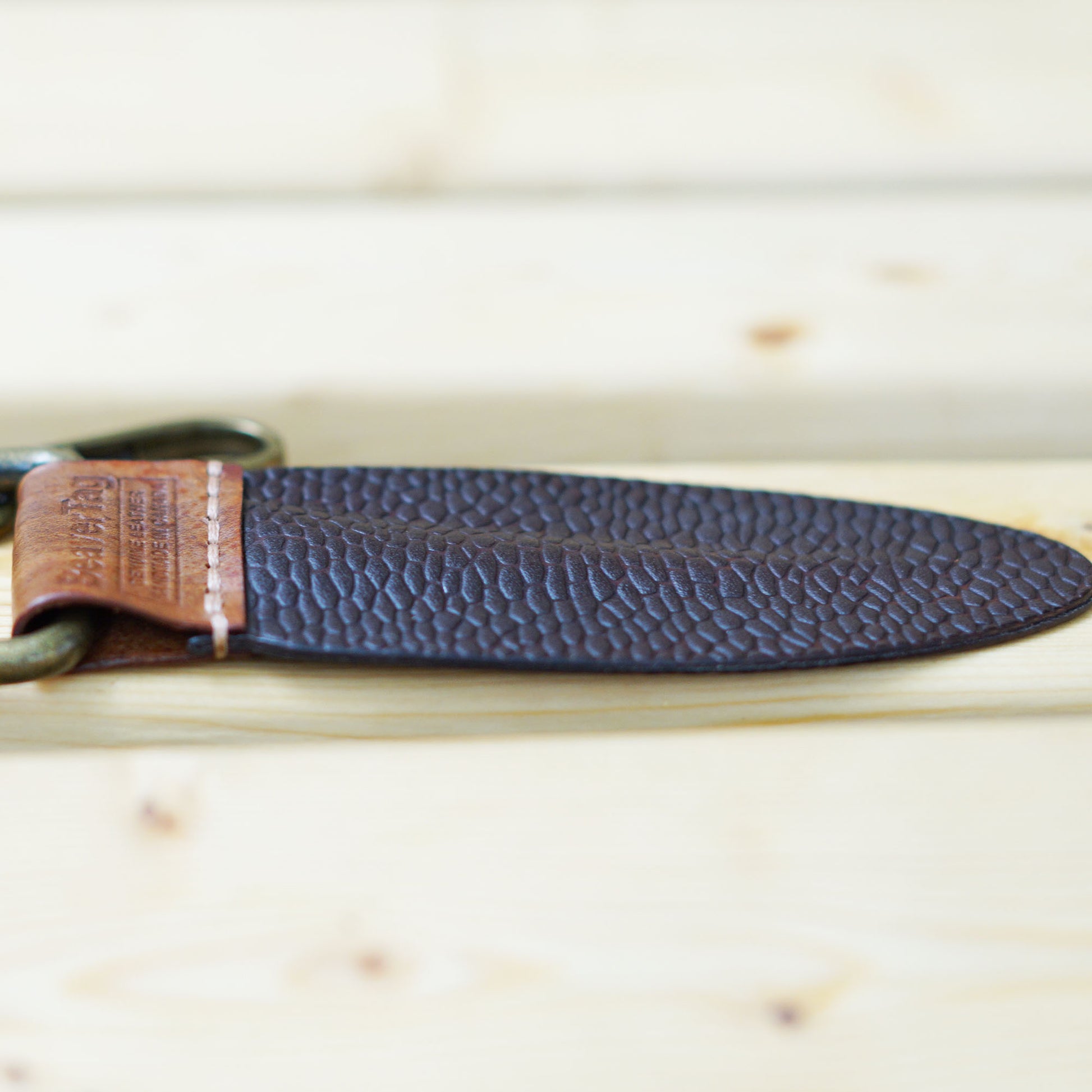 BeaverTag side shot showing the premium saddle stitch and the unique profile, thick at the center and tapering towards the edges, just like a real beaver's tail.